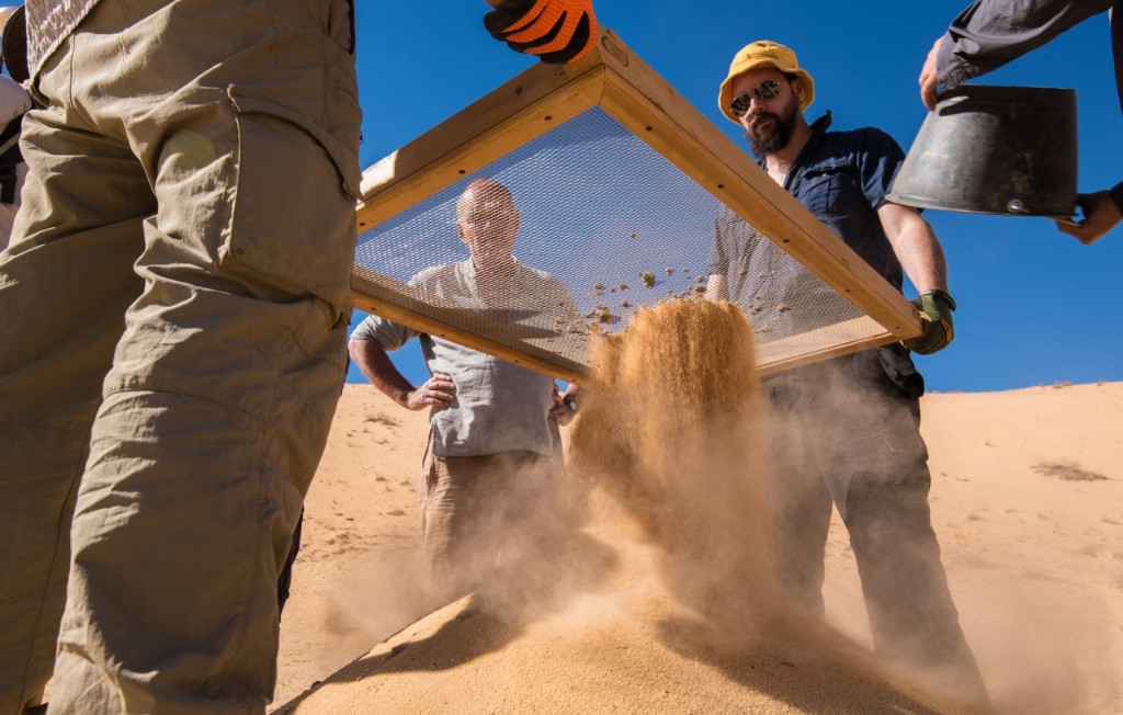 Archaeologists sieving sand at the Al Wusta site in the Nefud Desert