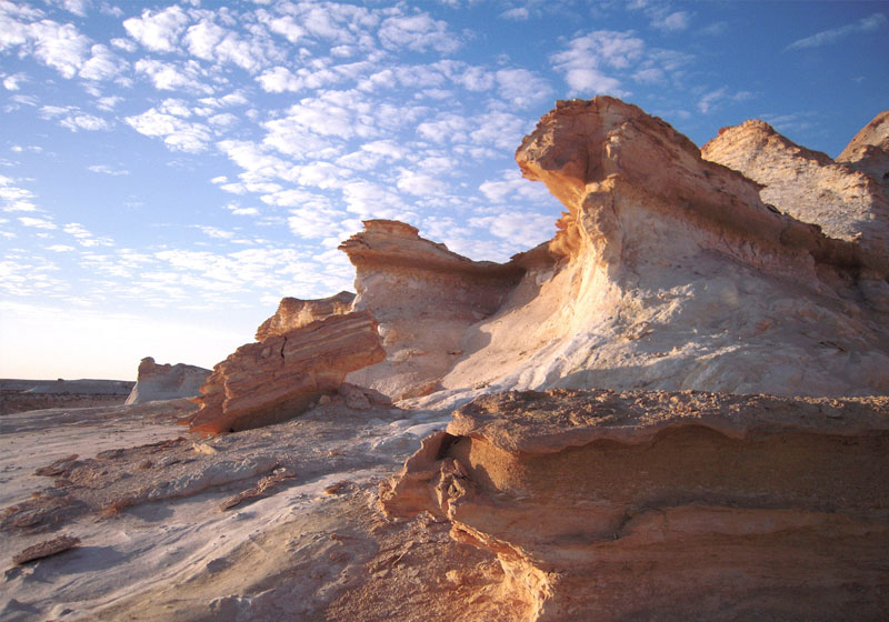 Eroded limestone cliff faces at Ad-Dahikiya with horizontal stratification and golden-hour light