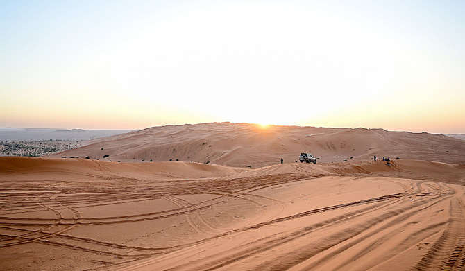 Khurais desert dunes at sunset with field vehicle and researchers on the Shark Teeth Trail